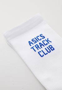 Chaussette de sport blanche en matériau texturé, avec broderie bleue "ASICS TRACK CLUB" à l'avant. Cuff à côtes en haut.