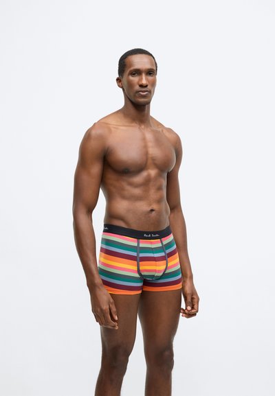 Ανδρικά ριγέ εσώρουχα με οριζόντιες ρίγες σε κόκκινο, πορτοκαλί, πράσινο και κίτρινο, με μαύρη ζώνη μέσης που φέρει το όνομα της μάρκας.