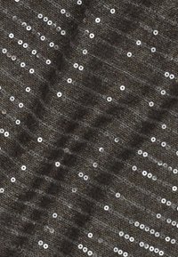 Tessuto lavorato a maglia scuro con piccole paillette argento lucide sparse che creano un sottile motivo testurizzato.