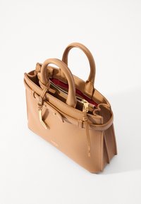 Tan leather handbag with rounded handles, zippered inner pocket, gold-tone hardware, and a textured finish. Red lining inside.