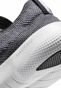 Czarno-białe sportowe buty ze wzorem, z cholewką z teksturowanej tkaniny, białą podeszwą środkową oraz wzorem na spodzie poprawiającym przyczepność. Subtelne elementy marki.