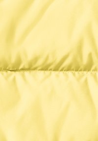 Gele pufferjack met een gladde textuur, geborduurd ontwerp met horizontale stiksels, voorzien van een glanzende afwerking.