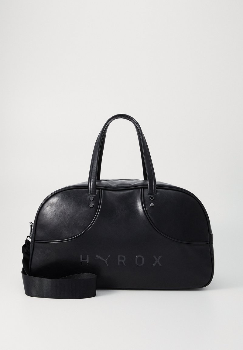 Sort læder rejsetaske med rund form, dobbelthåndtag og justerbar skulderrem. Har prægede "HYROX" logo foran.