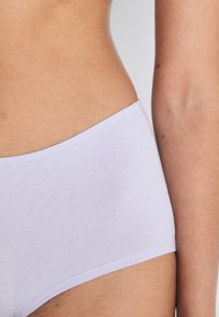 Lilla bomulls-stretch truse med en glatt tekstur og elastisk linning. Har et enkelt, søm-fritt design uten utsmykninger.