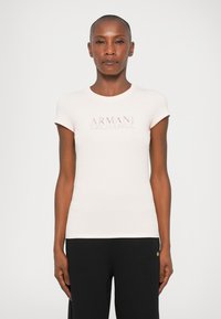 Tricou fucsia ajustat cu mâneci scurte, având logo-ul în relief "ARMANI EXCHANGE" într-o culoare contrastantă pe piept. Material moale din bumbac.