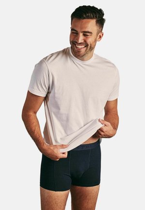 Wit katoenen T-shirt en marineblauwe boxershorts. Het T-shirt heeft een ronde hals en korte mouwen; de boxershorts hebben een tailleband met logo en een strakke pasvorm.