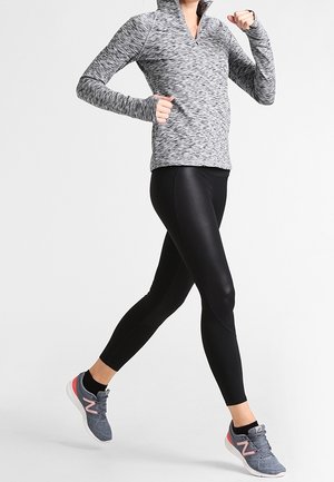 Gray, long-sleeve pullover with a half-zip collar, paired with black leggings and gray athletic shoes featuring pink accents. Smooth texture.