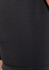 Černé sportovní šortky vyrobené z hladkého, elastického materiálu, které mají texturovaný vzor na jedné straně a přiléhavý pas.