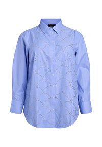 Light blue striped button-up shirt with a collar, featuring decorative silver circular cutouts on the front. Long sleeves with buttoned cuffs.