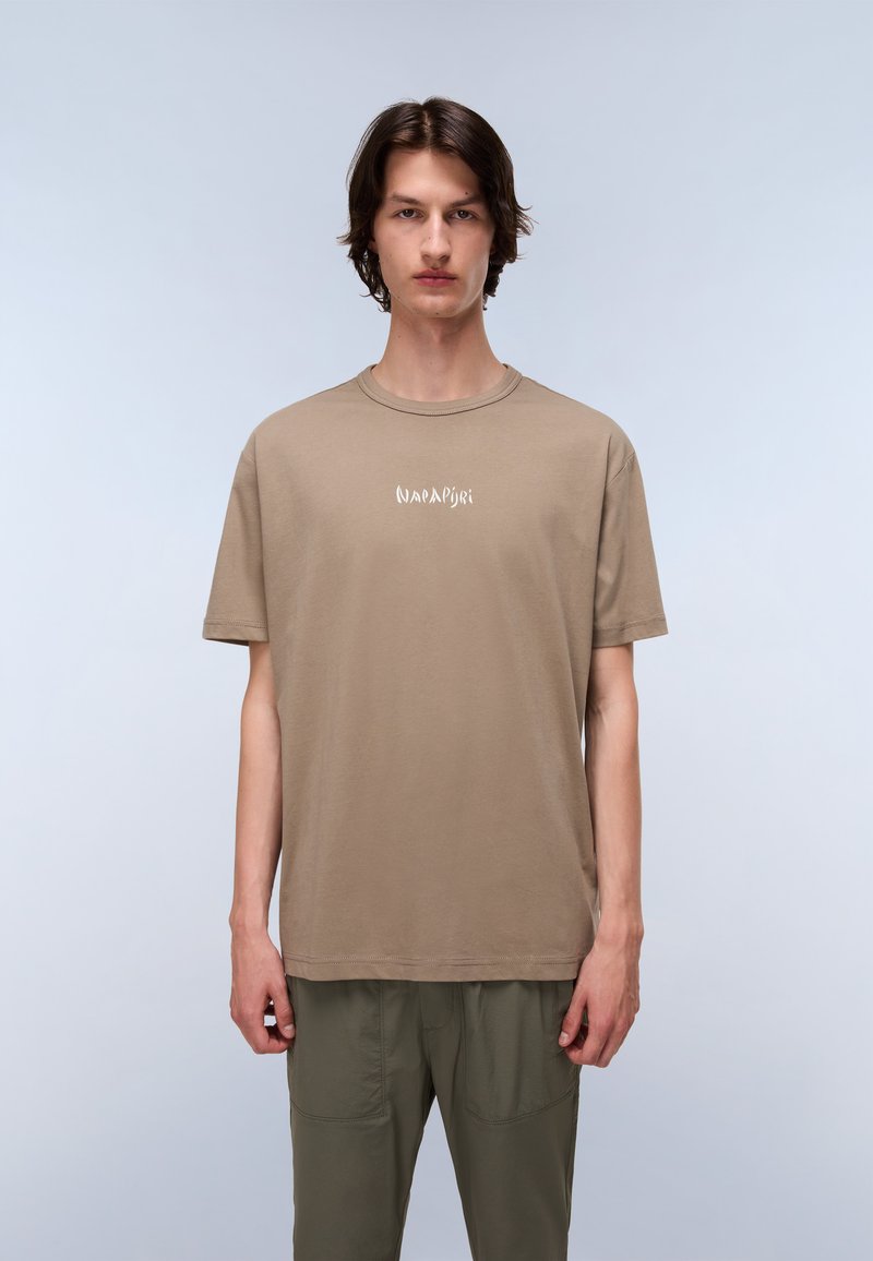 Brown cotton t-shirt featuring a crew neck, short sleeves, and a white logo print on the chest, paired with olive green pants.