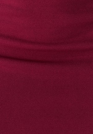 Tessuto color bordeaux con superficie morbida e testurizzata; presenta pieghe delicate che suggeriscono elasticità e un design aderente.
