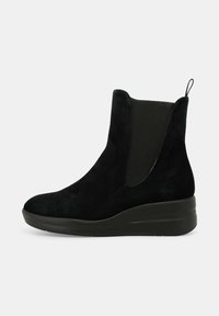 Stivale alla caviglia in suede nero con pannelli elastici sui lati, punta rotonda e un tacco a cuneo moderato per un'altezza e supporto aggiuntivi.