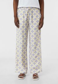 Teksturowane szerokie spodnie w pastelowych kolorach, z kwiatowym i geometrycznym wzorem, z elastycznym paskiem w talii i bocznymi kieszeniami.