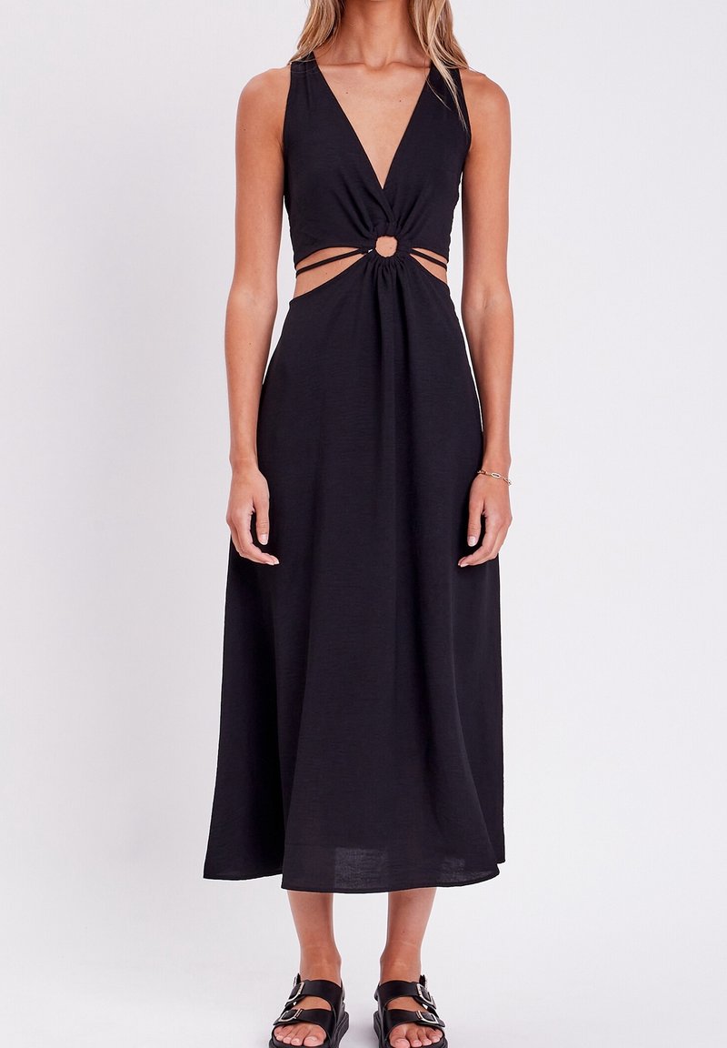 Robe maxi noire avec un décolleté en V profond, détail de nœud à la taille et découpes. Fabriquée en tissu léger, elle dispose de bretelles ajustables.