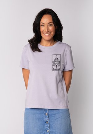 Lichtpaarse t-shirt met korte mouwen van zachte stof, met een zwarte grafische afdruk van de tarotkaart "De Keizerin" op de borst.