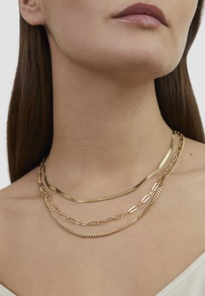 Gold layered necklaces featuring different styles: flat chain, oval link, and fine chain textures, all in a polished finish.