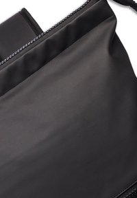 Black zippered bag with a smooth, matte finish; features a contrasting zipper and rounded top edge. Design is practical and minimalistic.