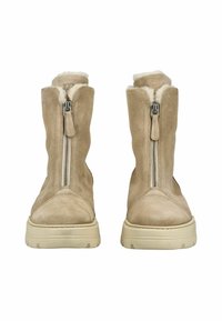 Botas de tobillo de ante beige con un acabado suave, detalle de cremallera lateral y un forro de piel sintética color crema en la parte superior. Suelas de goma gruesas.