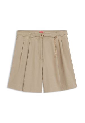Shorts plissés beige avec une ceinture fine assortie, boucle dorée et détail de chaîne décorative sur fond blanc.