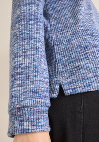 Gerippter Strickpullover in Blau- und Violetttönen mit strukturiertem Muster, ausgestattet mit langen Ärmeln und Seitenschlitzen am Saum.