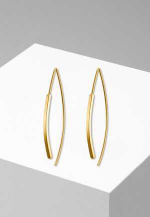 Goldfarbene Metallohrringe mit einer geschwungenen, länglichen Form. Glatte Oberfläche mit einem dezenten, glänzenden Finish. Minimalistisches Design auf einem weißen Hintergrund.