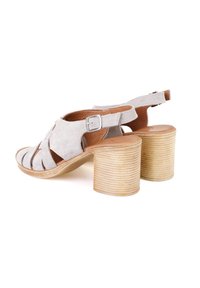 Graue Wildleder-High-Heel-Sandalen mit runder Zehenform, offenem Design, Knöchelriemen und einem strukturierten Holzblockabsatz.