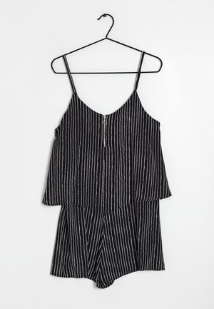 Schwarzer gestreifter Jumpsuit mit dünnen Spaghettiträgern und einem Frontreißverschluss, der eine lockere Passform oben und einen kurzen unteren Teil aufweist.