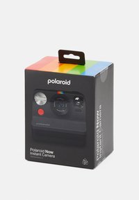 Polaroid Now Instant Camera packaging features a black box with a clear front, colorful top stripe, red button, and white logo text.