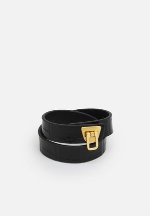 Schwarzes Lederwickelarmband mit strukturiertem Muster und Verschluss in Goldoptik, dargestellt in aufgerolltem Zustand auf weißem Hintergrund.