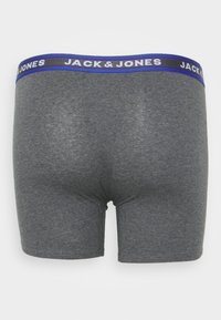 Graue Boxershorts mit weichem Material, mit einem blau-weißen elastischen Bund, auf dem "JACK & JONES" gedruckt ist.