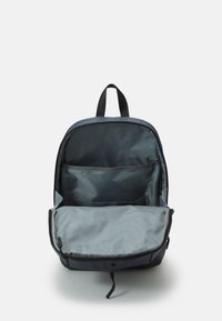 Laadukas tummansininen kangaskassi, jossa on iso pääosasto, harmaa sisustus, etutasku, kaksoissakko ja ylhäältä kantokahva.