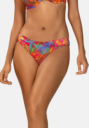 Kobieta ubrana w kolorowe bikini w tropikalny wzór, stojąca z opuszczonymi ramionami na białym tle.