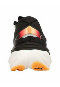 Sneaker nera con tomaia testurizzata, caratterizzata da un accento rosso e arancione sul tallone, e una suola intermedia bianca con dettagli arancioni sulla suola.