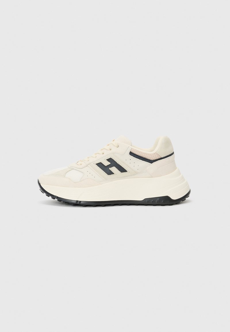 Sneakers met een crèmekleurige bovenkant van gemengde materialen, met een zwart logo, getextureerde accenten en een chunky witte zool met zwarte profiel.