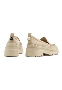 Beżowe buty wsuwane na chunky platformie, górna część z gładkiej skóry, z okrągłym akcentem logo na pięcie. Charakteryzują się zaokrąglonym noskiem.