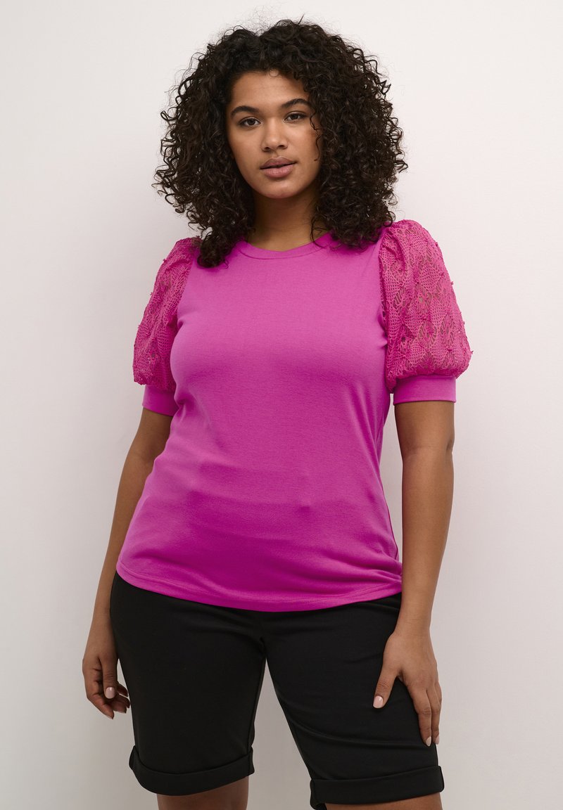 Fuchsia short-sleeve t-shirt with lace puff sleeves, paired with black knee-length shorts. Smooth fabric with a fitted design.