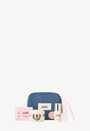 Compact nail care kit with denim pouch, gel polish, gel removal wraps, LED lamp, nail file, and cuticle stick.