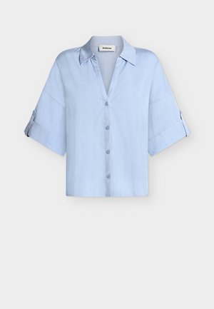 Ανοιχτό μπλε πουκάμισο με κουμπιά, φαρδιές κοντές μανσέτες και γιακά, με λουράκια στο μανίκι για να πιέζονται επάνω.