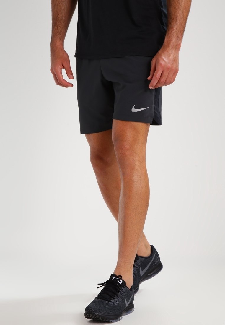 Pantalones cortos deportivos Nike negros con un logo gris, hechos de material ligero. El diseño presenta un ajuste cómodo y un corte moderno.