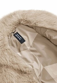 Beige nepbont voering met een gladde beige stoffen binnenkant. Voorzien van een merklabel en een pluizige textuur bij de kraag.