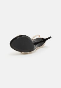 Musthave musta kontsavaba sandaal, millel on sile läikiv viimistlus, beeži rihmaga ja avatud seljaga disain. Tallal on läikiv tekstuur ja minimaalne haardumine.