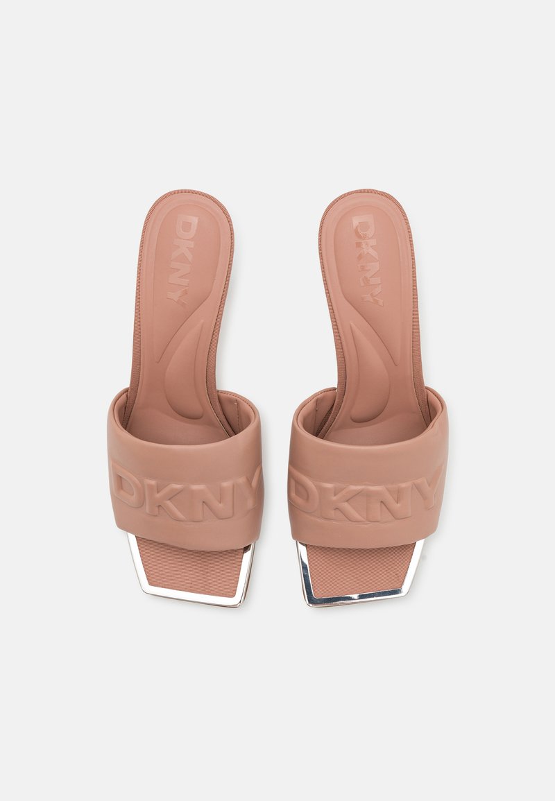 Sandały klapki DKNY w miękkim brązowym gumie z teksturowanymi paskami, z szeroką taśmą i błyszczącymi, srebrnymi akcentami na obcasie w kształcie prostokąta.