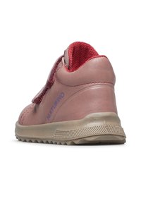 Růžová kožená dětská bota s texturovaným červeným látkovým akcentem, suchým zipem a robustní gumovou podrážkou pro lepší trakci. Obsahuje logo značky.