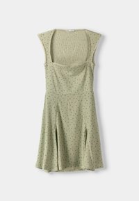 Abito senza maniche di un verde chiaro, con corpetto aderente, gonna ampia e piccolo motivo a pois neri su tessuto a coste.