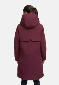 Maroon hooded parka with a mid-length design, featuring a flap detail on the back and embossed branding on the hood. Smooth fabric texture.