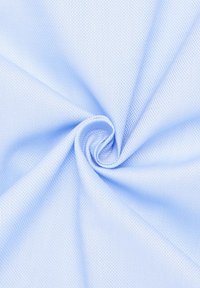 Lichtblauwe geweven stof met een geruit patroon. Het materiaal is soepel en valt in een spiraalvorm, wat de flexibiliteit laat zien.