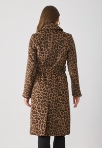 Luipaardprint jas in bruin en zwart, met een ceintuur in de taille, lange mouwen en een geknipte kraag. Getextureerde stof met zijsplitdetail.