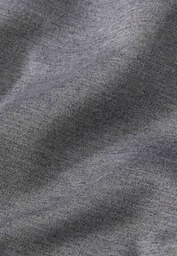 Tissu tricoté gris moyen doux avec une texture fine et homogène et des plis subtils créant de douces ombres et des reflets.