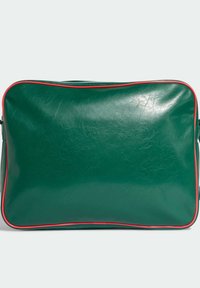 Zielona skórzana torba o gładkiej teksturze, prostokątnym kształcie i czerwonym obszyciu na brzegach. Zapięcie na zamek błyskawiczny na górze.