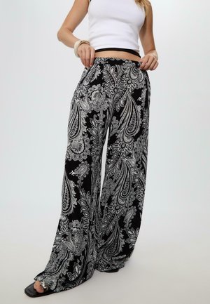 Black and white paisley patterned wide-leg pants made of lightweight fabric, featuring an elastic waistband and a relaxed fit.